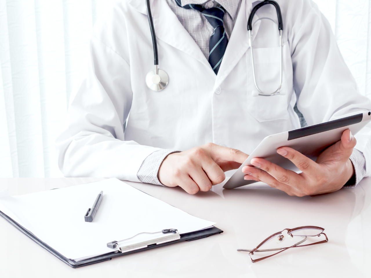 Doctor using a tablet to check clinic website performance