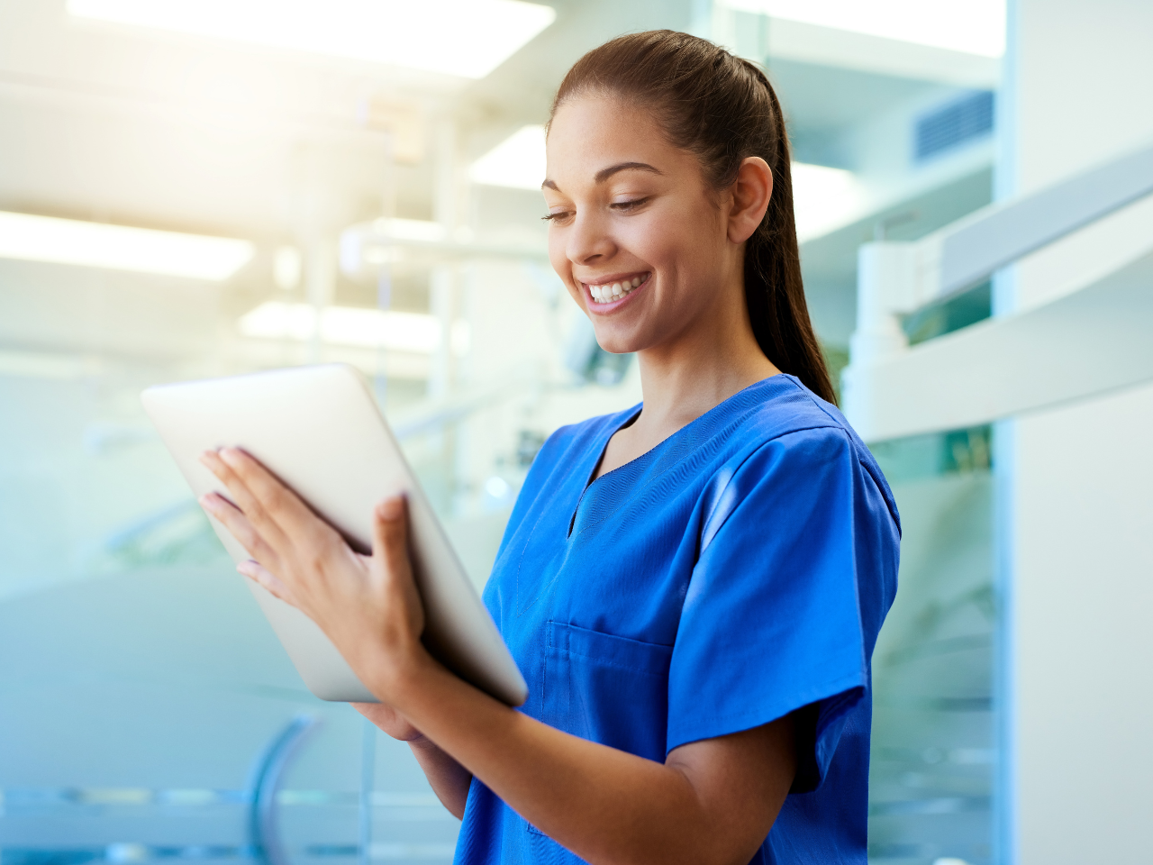 shot of a young nurse using a tablet while standing inside a clinic