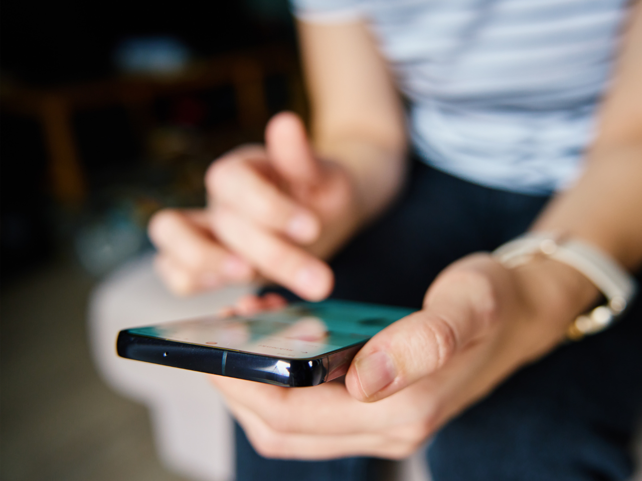 Person Browsing Social Media on Smartphone Indoors