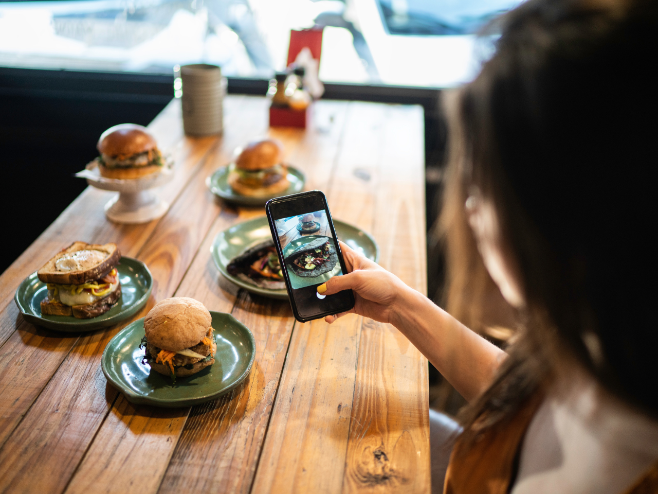 Influencer woman filming the hamburger table