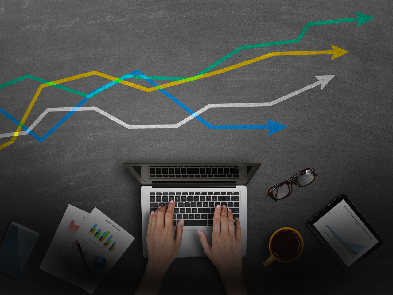 Hands typing on laptop with performance graph